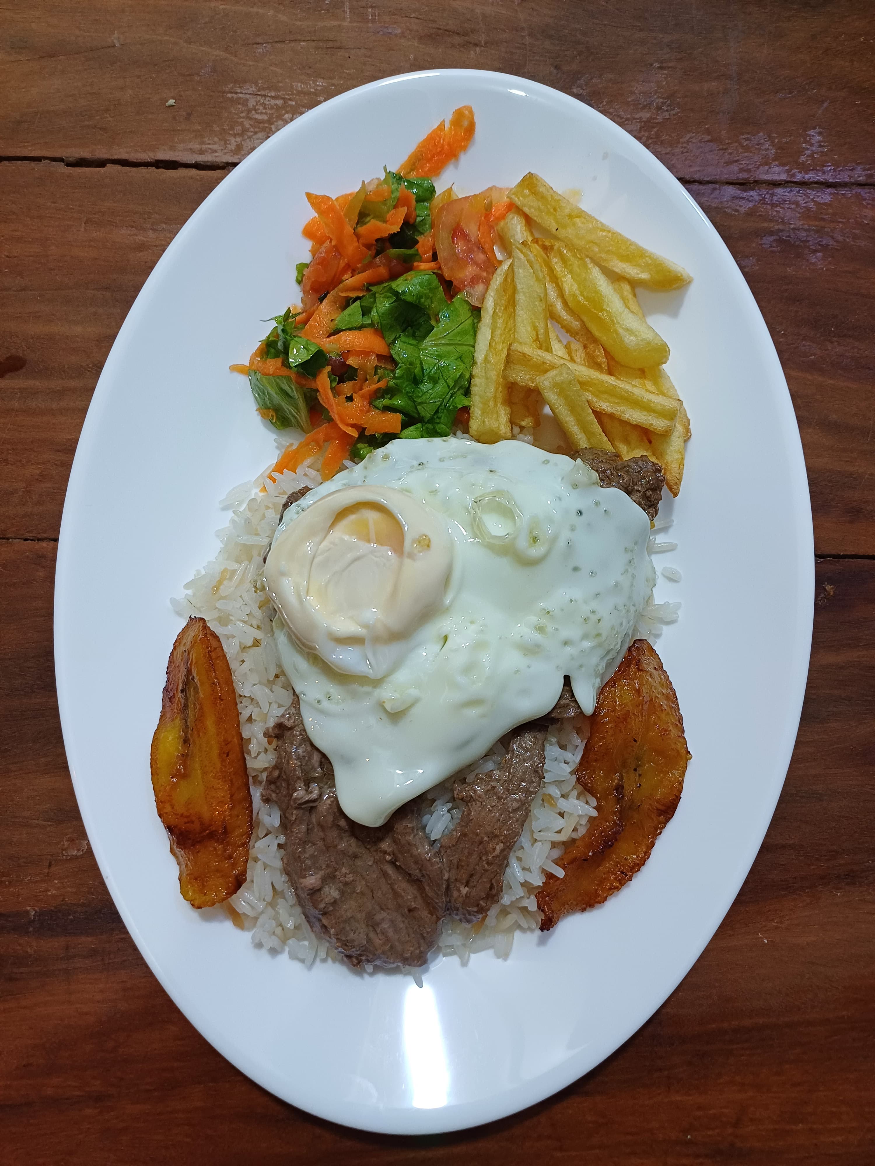 Plato con huevo frito, plátano y ensalada en El Camba
